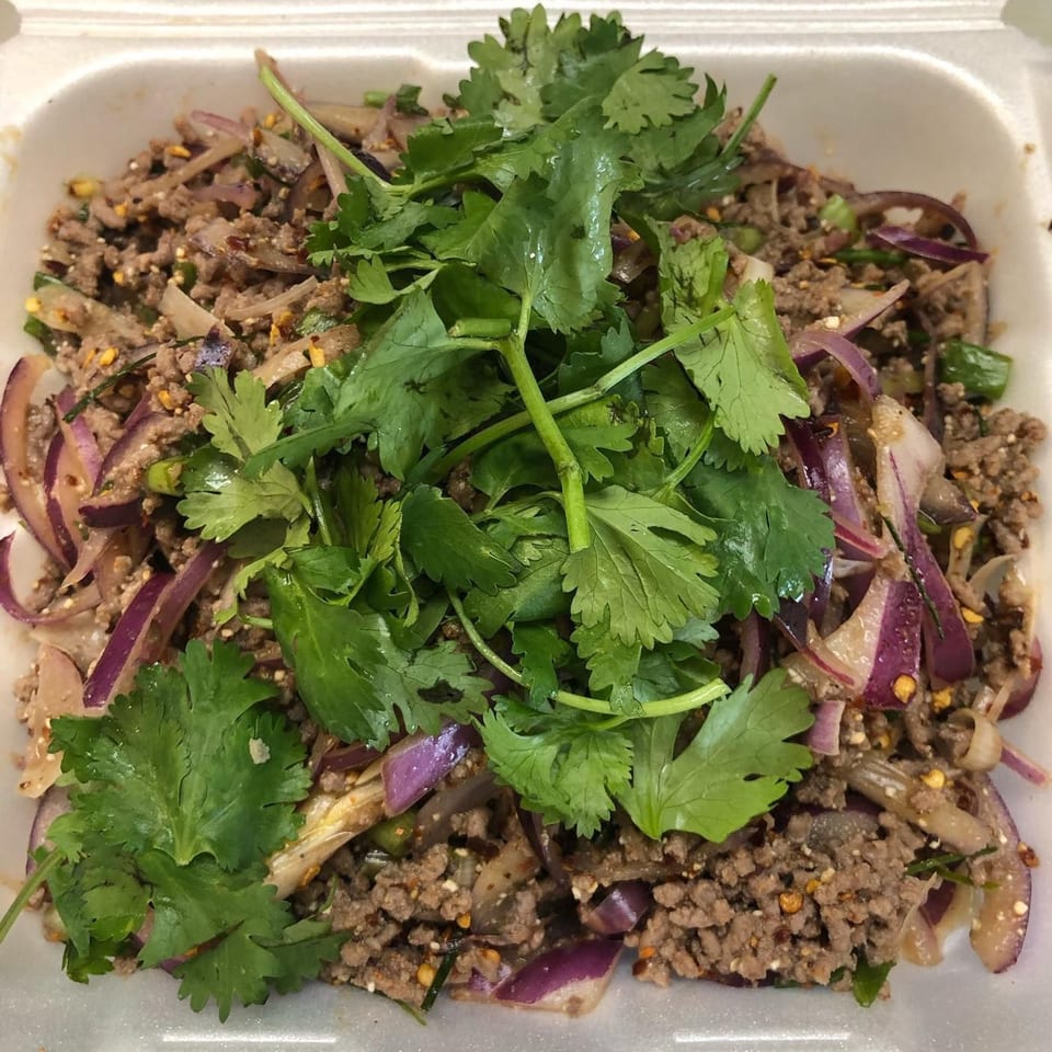 A close-up of The Asian Express's minced meat dish with red onions and fresh cilantro.